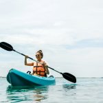 young woman kayaking on lake