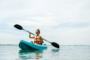 young woman kayaking on lake