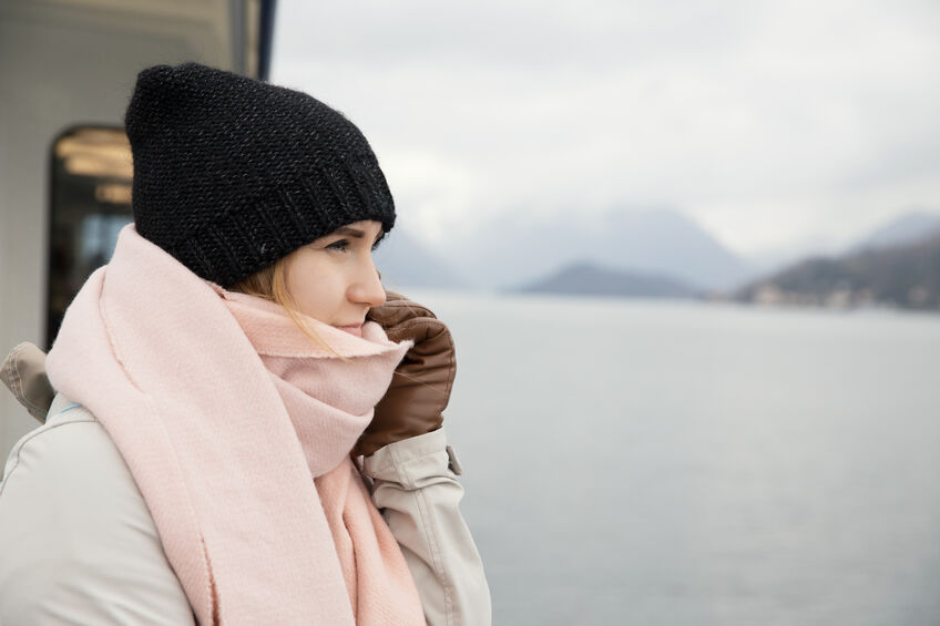 woman keeping warm on a boat