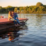 young family sitting on a dock