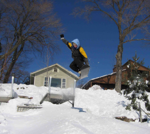 man snowboarding near dock