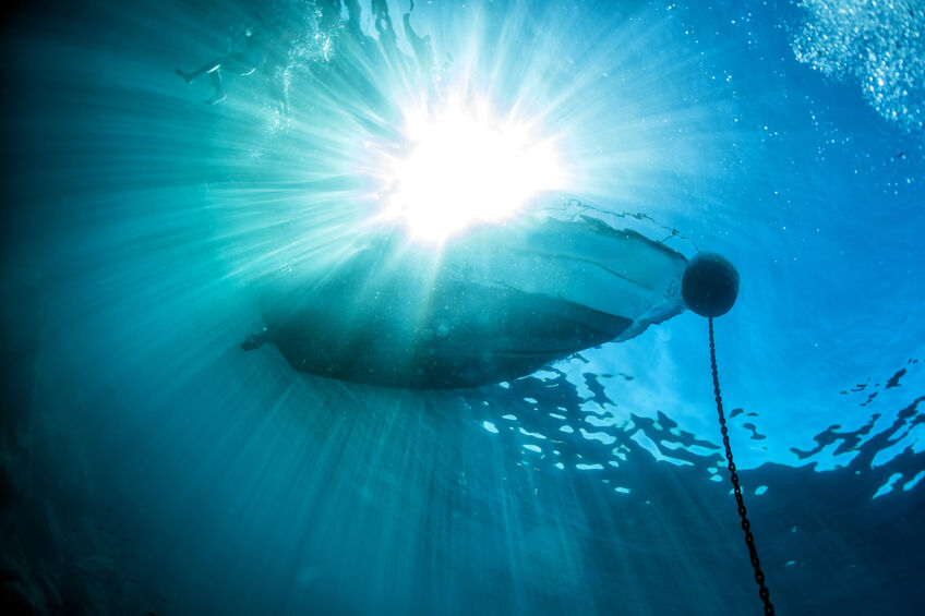 boat chain anchor from underwater with sun rays