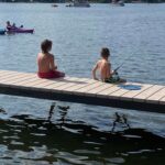 Two boys fishing off the side of a V-Dock
